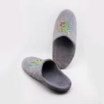 Close-up of grey embroidered wool slippers, reinforced toe