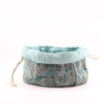 Drawstring Termeh pouch fully open showing pale sky-blue satin lining
