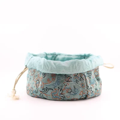 Drawstring Termeh pouch fully open showing pale sky-blue satin lining