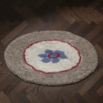 Detail of Handmade Turkmen Felt Round Mat blue flower on natural sheep wool