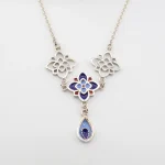 Close-up of authentic Persian cloisonné enamel blue flower motif on pure 990 silver pendant necklace