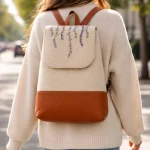 Full view of handmade embroidered felt backpack with premium goat leather accents and reinforced handle