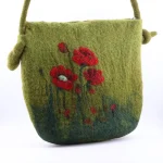 Handmade felt crossbody bag in green with red poppy wool painting by Iranian Turkmen artisan, zipper open showing blue lining