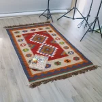 Full view of reversible Luri kilim rug with red field and Guli-Guli medallions