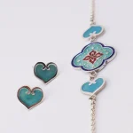 Close-up of handmade Persian cloisonné enamel heart bracelet with turquoise and red floral details on sterling silver