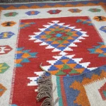 Detail of colorful hexagonal göl motifs on ivory border
