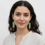 Turkmen hand-embroidered earrings hanging, showing colorful geometric patterns